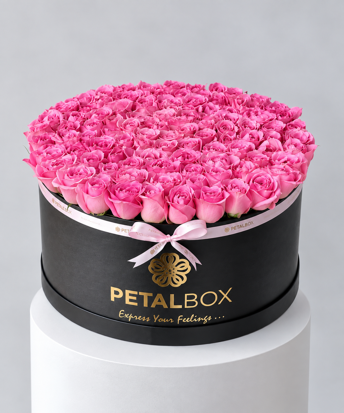 luxury pink rose arrangement in a black Petal Box hatbox, filled with a dense dome of fresh pink roses and finished with a soft pink ribbon, elegant flower gift for Abu Dhabi and Dubai