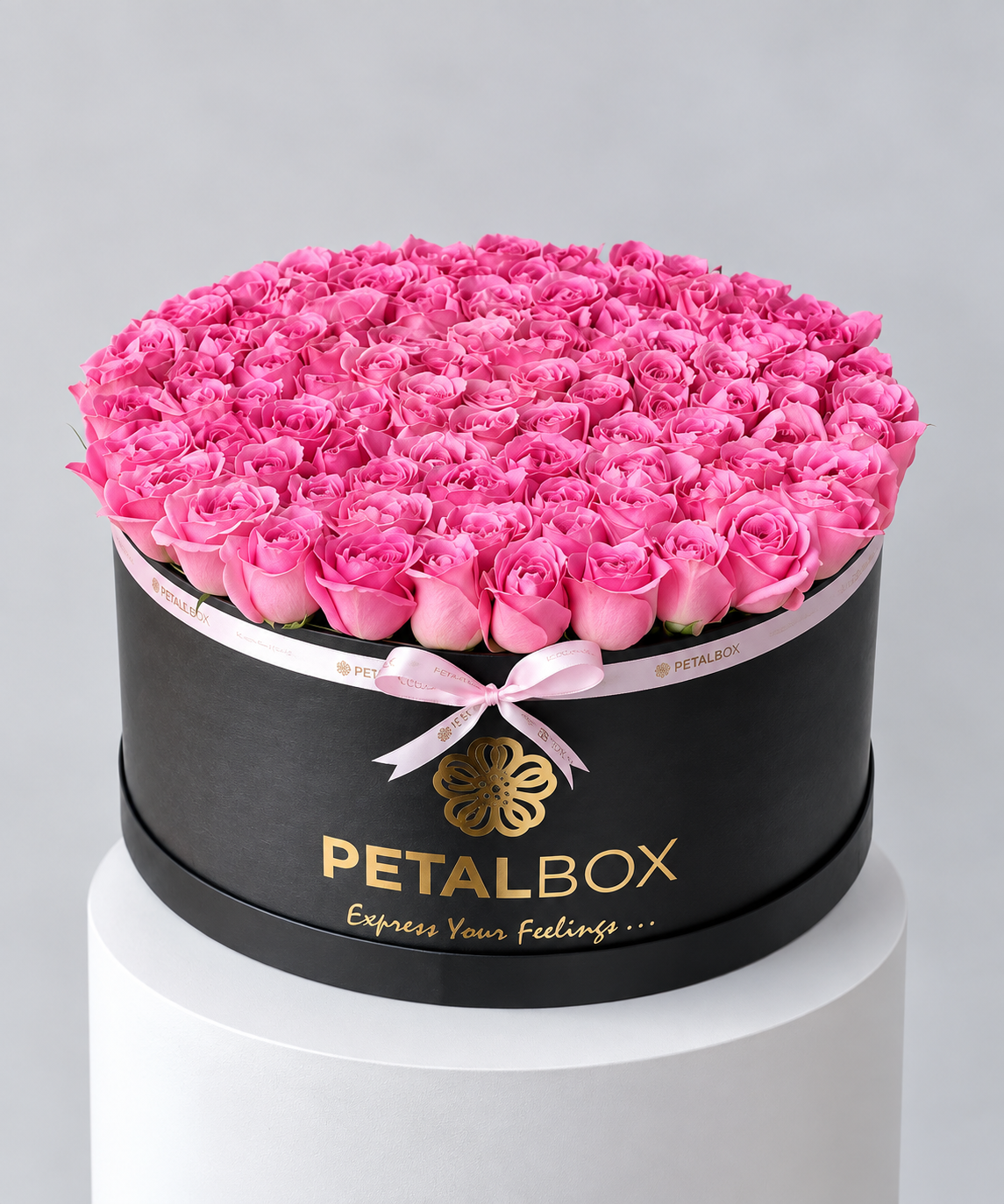 luxury pink rose arrangement in a black Petal Box hatbox, filled with a dense dome of fresh pink roses and finished with a soft pink ribbon, elegant flower gift for Abu Dhabi and Dubai