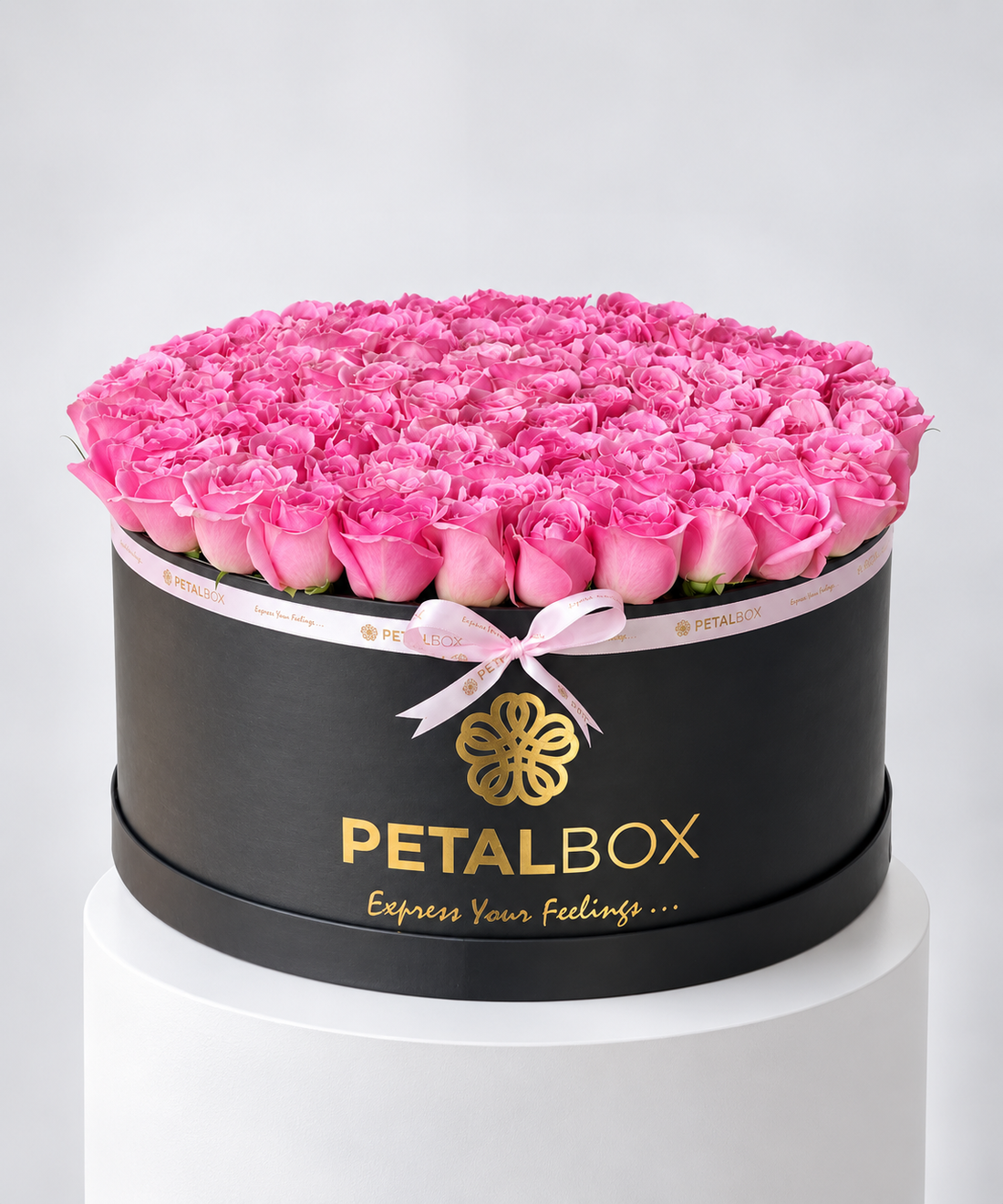 luxury pink rose arrangement in a black Petal Box hatbox, filled with a dense dome of fresh pink roses and finished with a soft pink ribbon, elegant flower gift for Abu Dhabi and Dubai