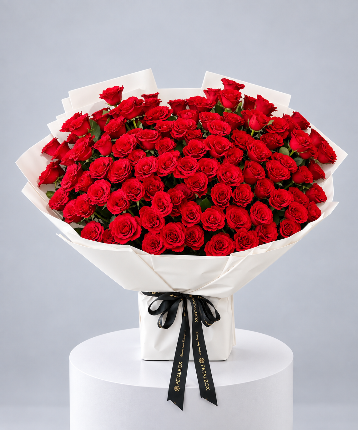 luxury red rose bouquet featuring a large arrangement of fresh red roses wrapped in white paper with a black Petal Box ribbon, elegant romantic flower gift for Abu Dhabi and Dubai