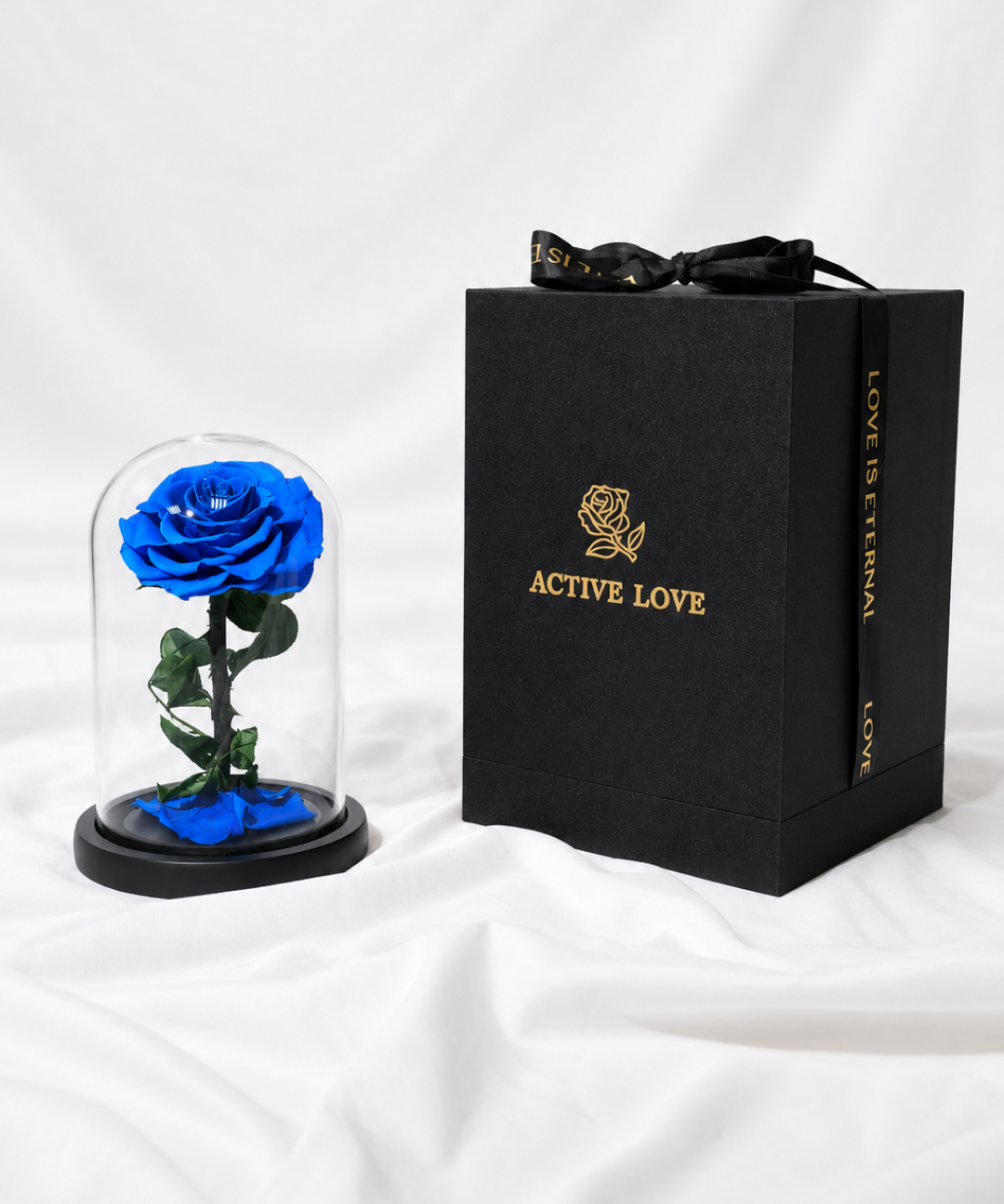 Luxury blue forever rose preserved under a clear glass dome with a premium black Active Love gift box featuring elegant gold branding, an everlasting blue rose gift for anniversaries, birthdays and romantic occasions, available from Petal Box with flower delivery in Abu Dhabi and Dubai, UAE.