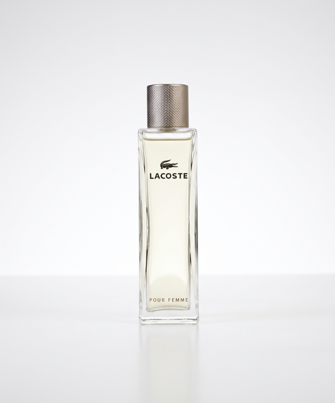 Lacoste Pour Femme Eau de Parfum for Women 90ml, featuring an elegant slim glass perfume bottle with a gold textured cap and matching silver packaging, available for women's designer perfume shopping in Abu Dhabi, Dubai and across the UAE.