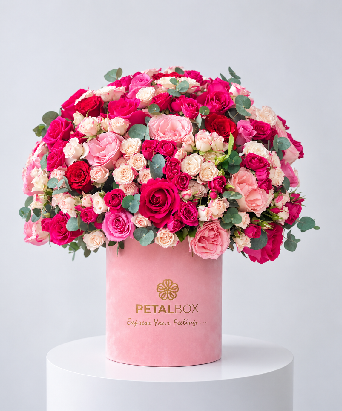 luxury pink rose bouquet in a Petal Box hatbox featuring red, pink, hot pink and cream roses with eucalyptus foliage, elegant floral arrangement for gifting in Abu Dhabi and Dubai