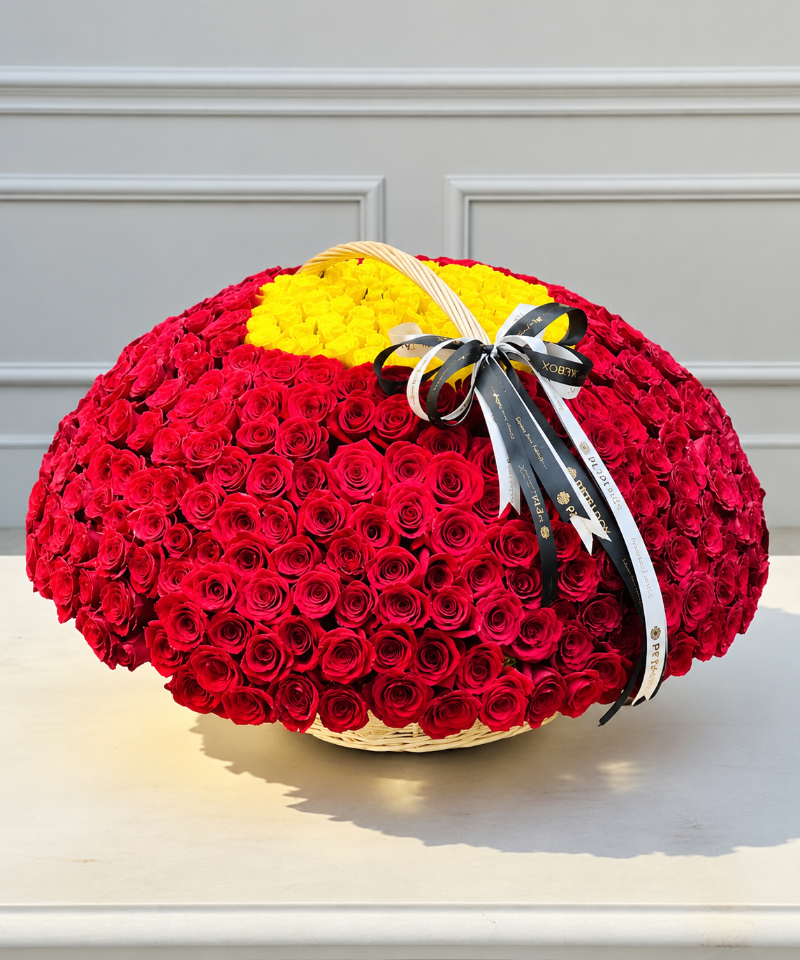 luxury 501 red rose basket arrangement featuring hundreds of fresh red roses with a bright yellow rose center, finished with elegant black and white Petal Box ribbons for premium gifting in Abu Dhabi and Dubai