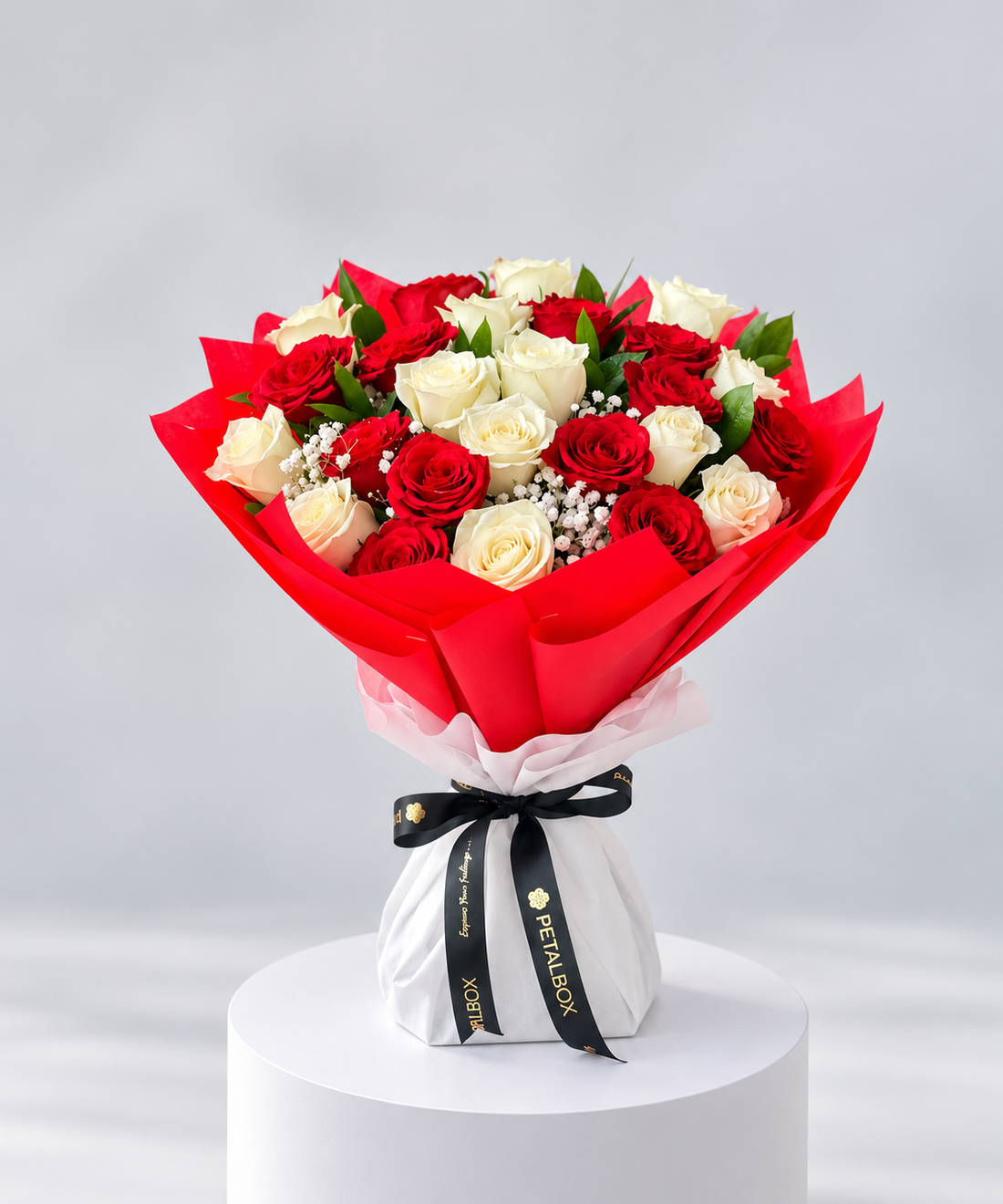 luxury red rose bouquet featuring fresh red roses and delicate white baby’s breath, wrapped in vibrant red and white paper with a black Petal Box ribbon, elegant romantic flower gift for Abu Dhabi and Dubai