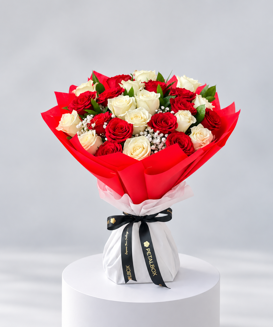 luxury red rose bouquet featuring fresh red roses and delicate white baby’s breath, wrapped in vibrant red and white paper with a black Petal Box ribbon, elegant romantic flower gift for Abu Dhabi and Dubai