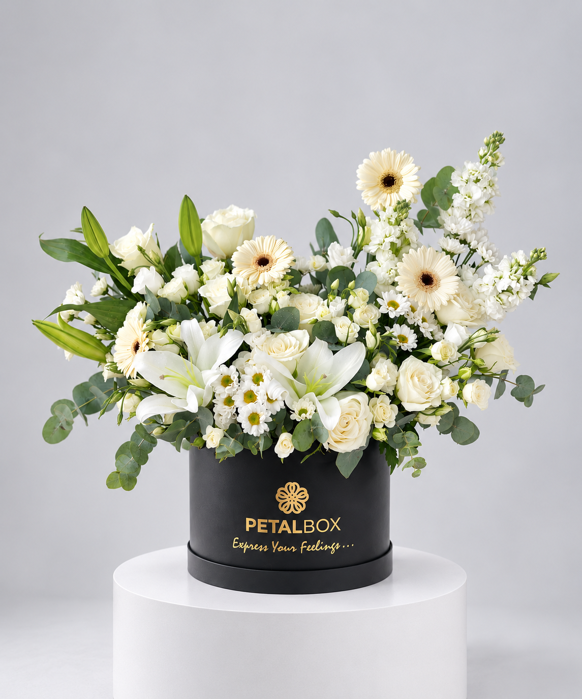 luxury white flower arrangement in a black Petal Box featuring white roses, lilies, gerbera daisies, chrysanthemums, spray flowers and eucalyptus foliage, elegant floral gift for Abu Dhabi and Dubai