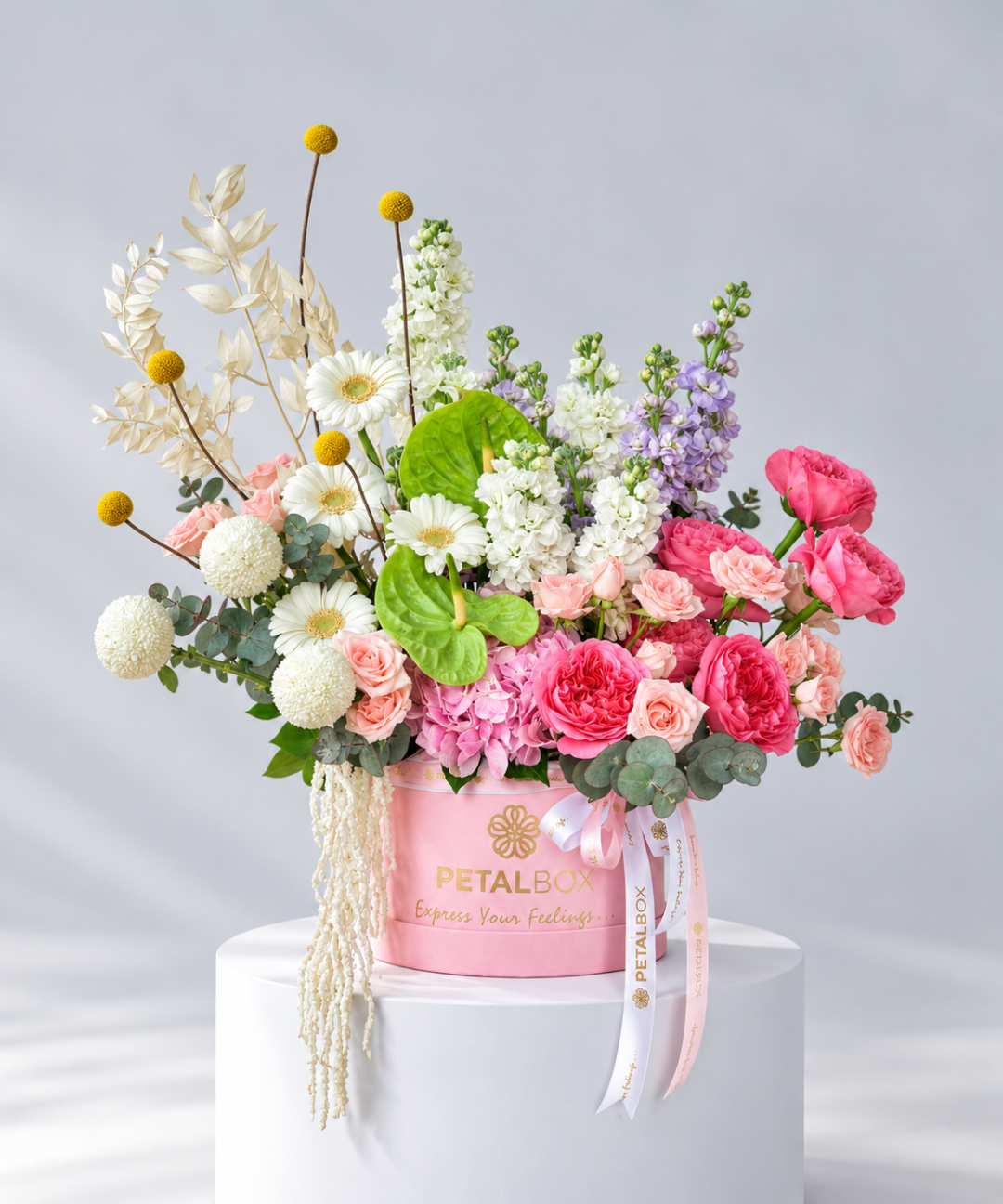 Pink roses, white gerbera and green anthurium in a round pink velvet hatbox