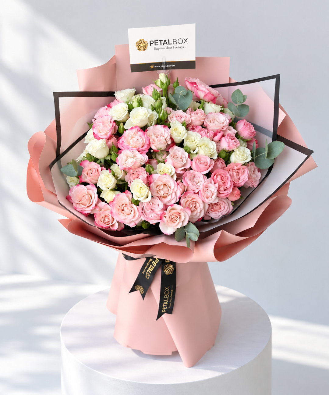 Luxury pink and white rose bouquet with fresh eucalyptus leaves, wrapped in elegant blush pink and black floral paper with Petal Box branded ribbons, perfect for birthdays, anniversaries and romantic flower delivery in Abu Dhabi and Dubai, UAE.