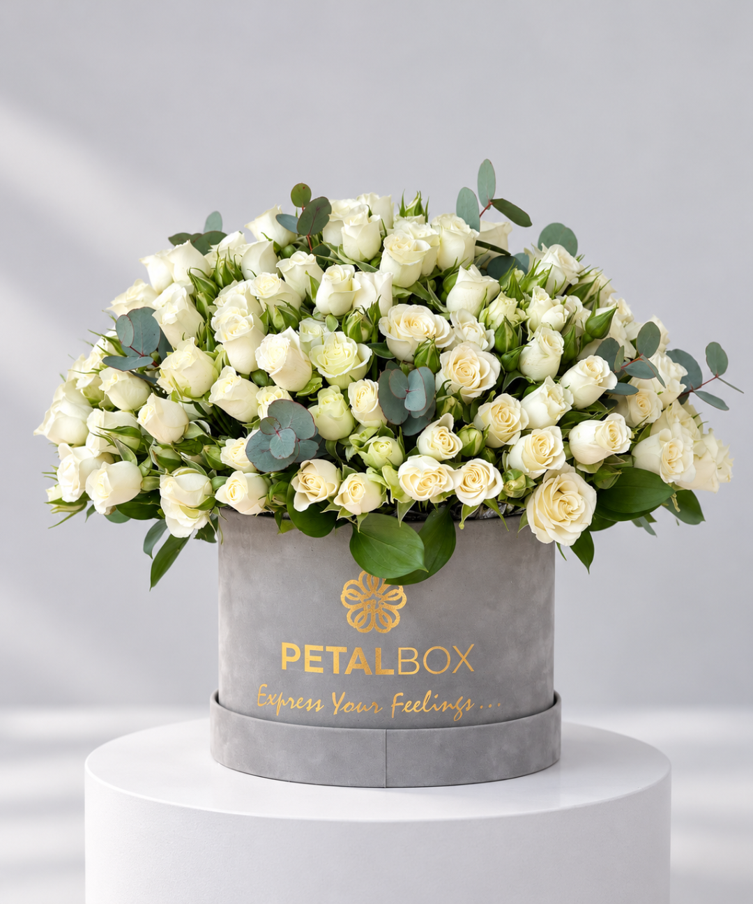 Luxury White spray rose bouquet featuring premium white spray roses and fresh eucalyptus foliage, arranged in a grey Petal Box flower hatbox with elegant gold branding. Ideal for birthdays, anniversaries and elegant gifting, with flower delivery in Abu Dhabi and Dubai, UAE.