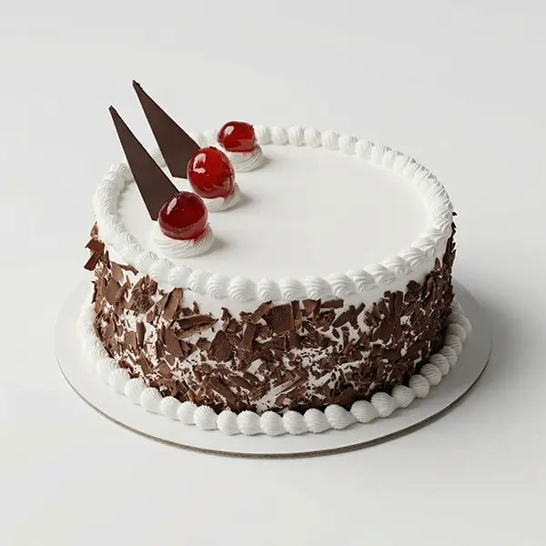Black Forest cake with whipped cream frosting, chocolate shavings, and cherry topping
