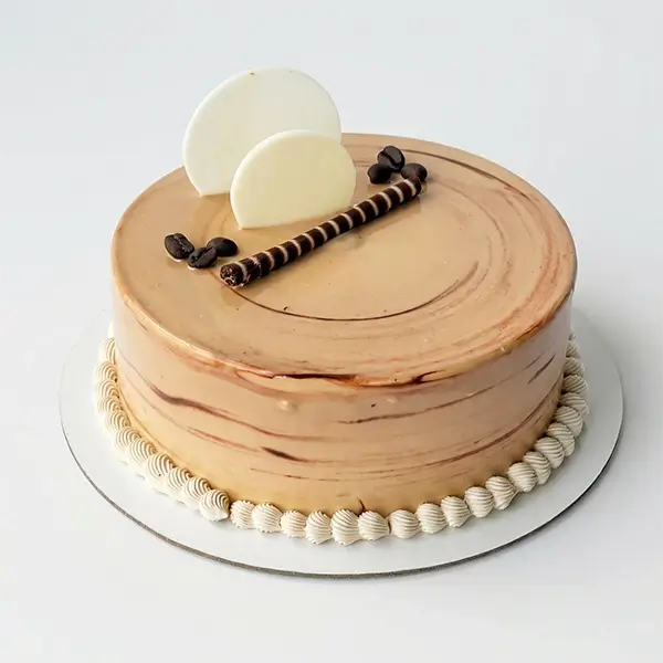 Coffee caramel cake with smooth glaze, coffee beans, and chocolate decoration