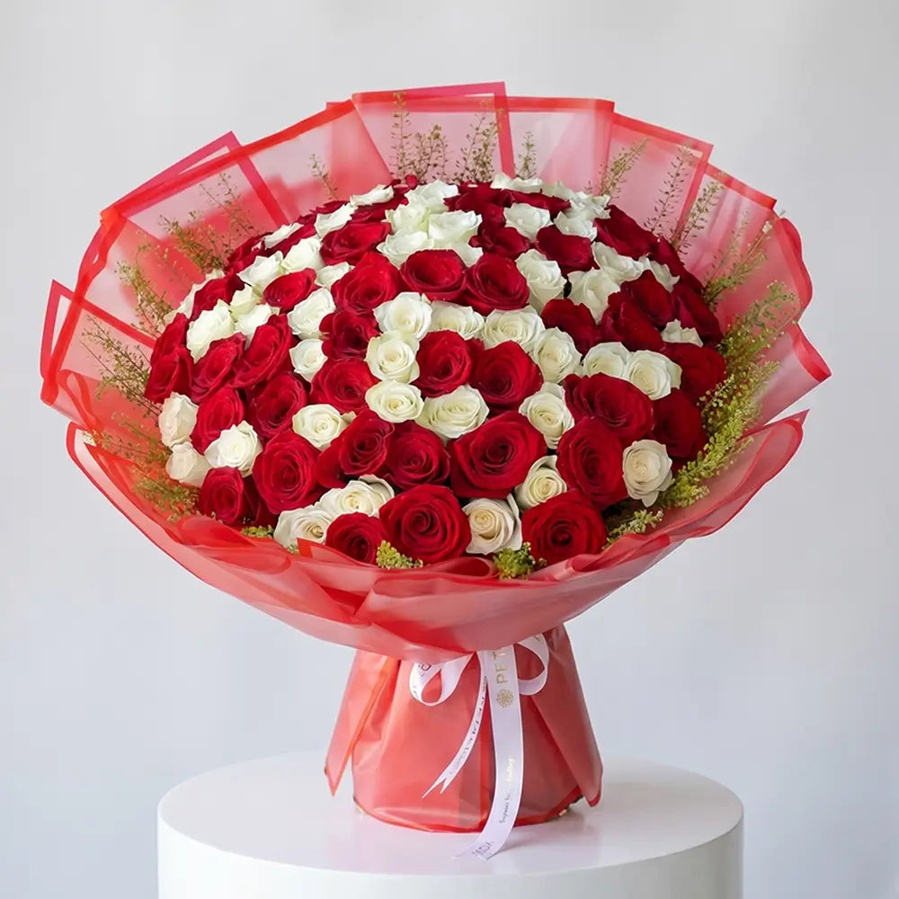 Luxury red and white rose bouquet with elegant orange wrapping and fresh greenery, designed for romantic gifting and special occasions by Petal Box.