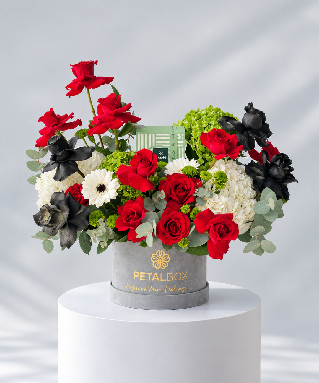 Grey velvet box with red and black roses, hydrangea, gerbera and Patchi chocolate