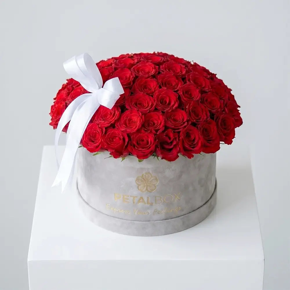 Luxury red rose flower box arrangement with fresh red roses and elegant white ribbon in a premium velvet Petal Box, perfect for romantic gifting in Abu Dhabi and Dubai.