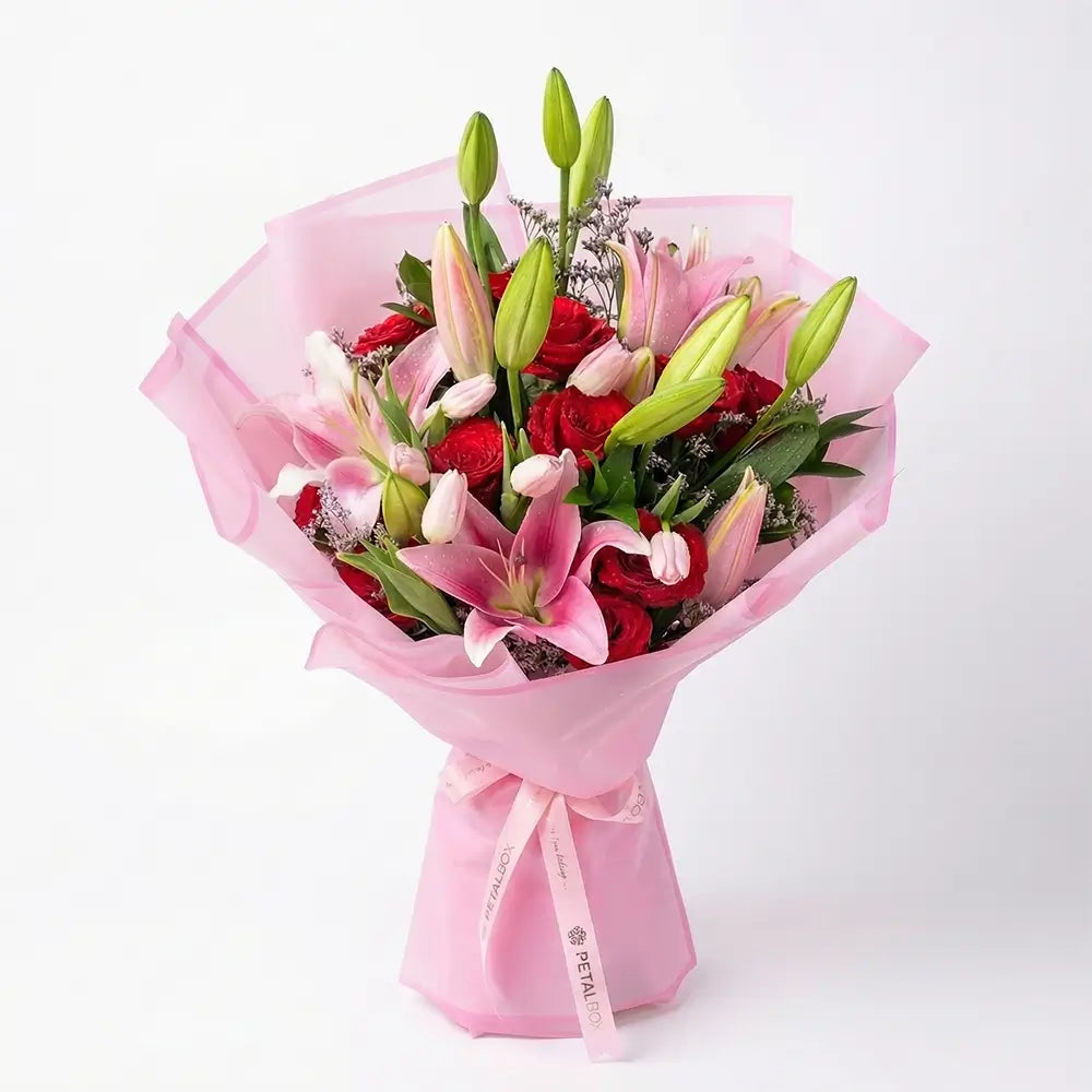 pink lily bouquet with red roses and white tulips in elegant pink wrapping, luxury mixed flower bouquet by Petal Box UAE for flower delivery in Abu Dhabi and Dubai
