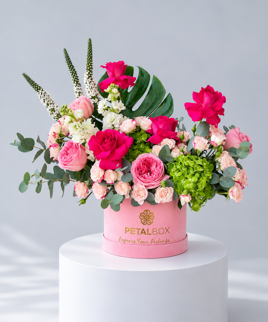 Pink roses and green hydrangea with white veronica in a pink velvet hatbox