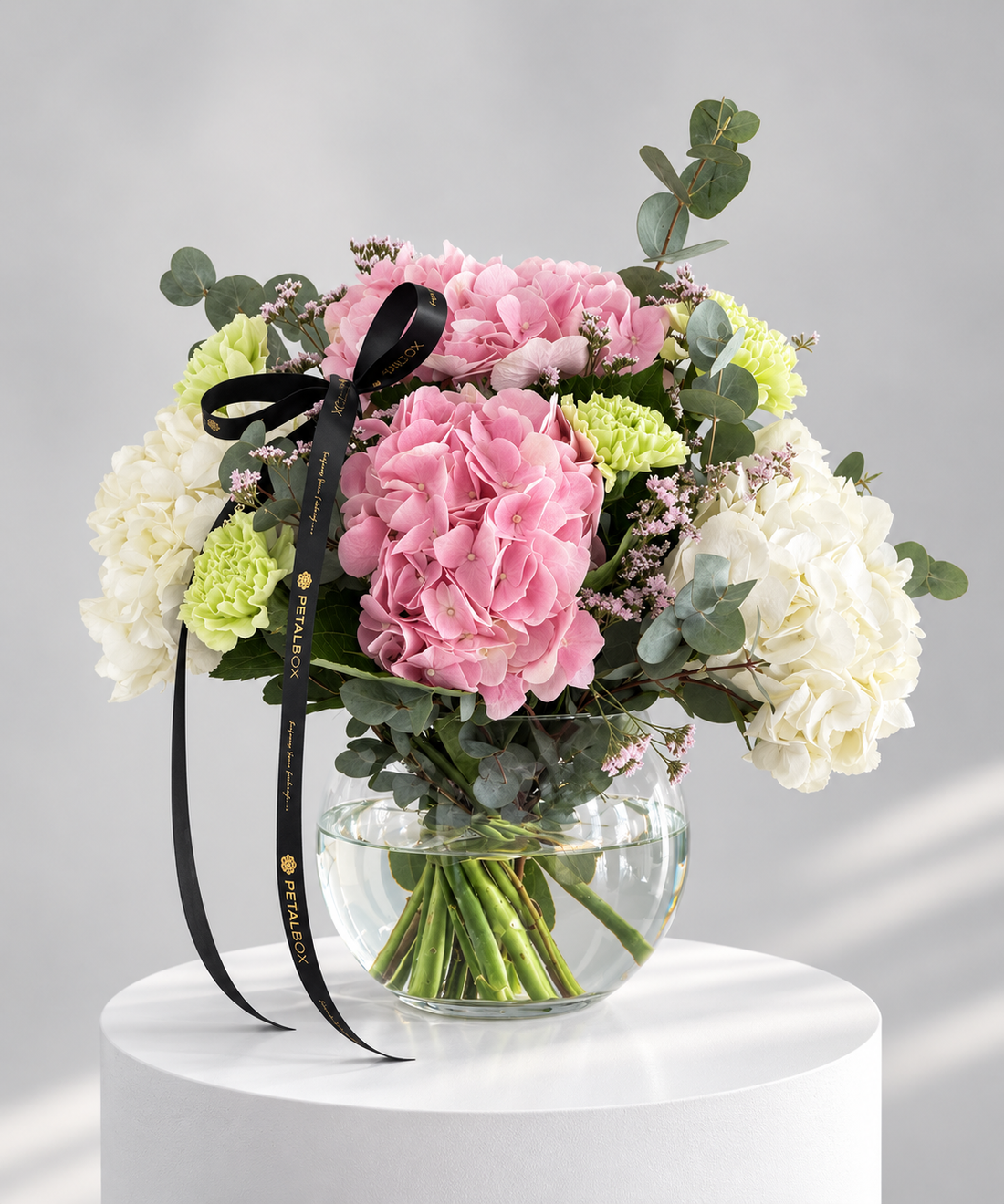 Pink and white hydrangea with carnation flower arrangement in a glass bowl by Petal Box