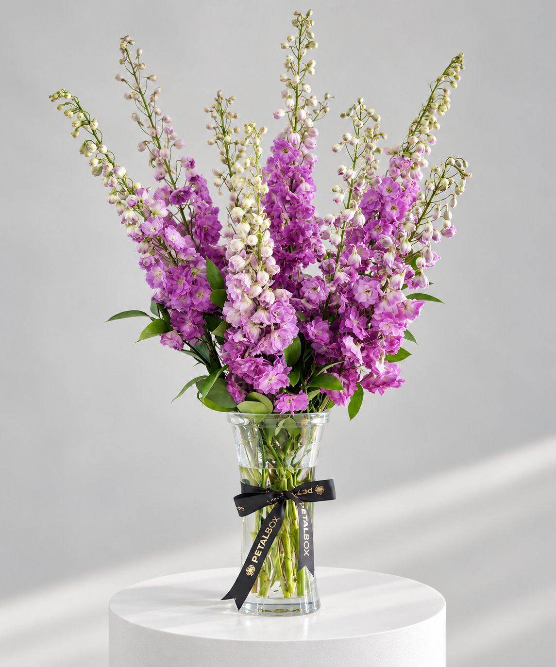 Purple delphinium flower arrangement in a clear glass vase by Petal Box