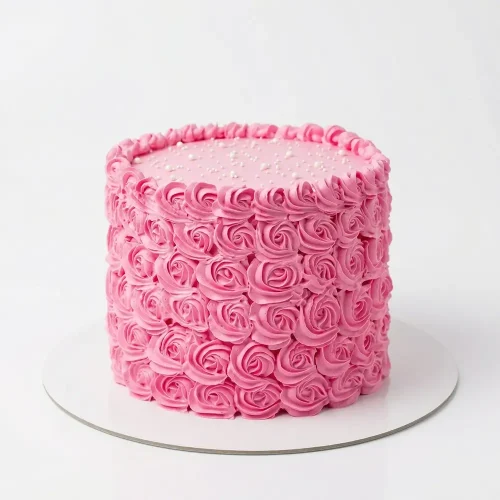 Pink rosette buttercream cake with full swirl rose texture, pearl dot top and piped border — elegant birthday cake delivery Petal Box Abu Dhabi