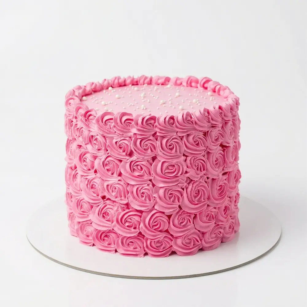 Pink rosette buttercream cake with full swirl rose texture, pearl dot top and piped border — elegant birthday cake delivery Petal Box Abu Dhabi
