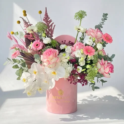 Elegant pink flower box arrangement with roses, orchids, gerbera daisies, and eucalyptus in a luxury Petal Box gift container