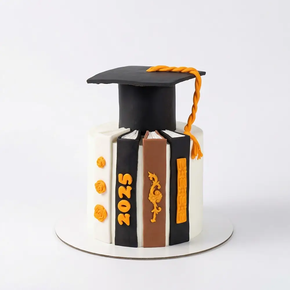 Class of 2025 graduation cake with fondant mortarboard cap, stacked books and gold tassel — custom order Petal Box Abu Dhabi