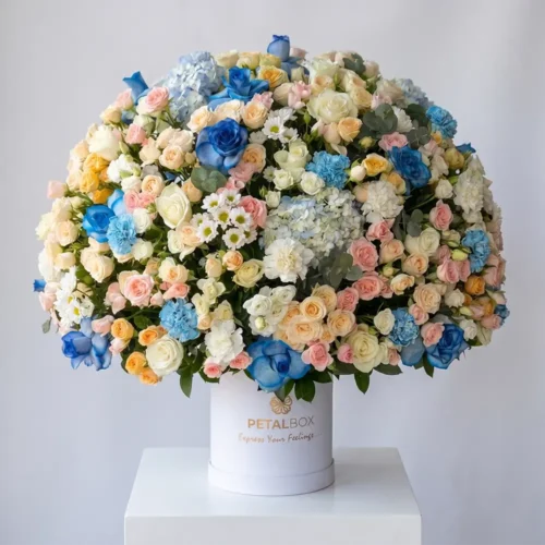 lavish mixed flower box with blue roses, hydrangeas, spray roses and white blooms, luxury floral arrangement in white hat box by Petal Box UAE for flower delivery in Abu Dhabi and Dubai