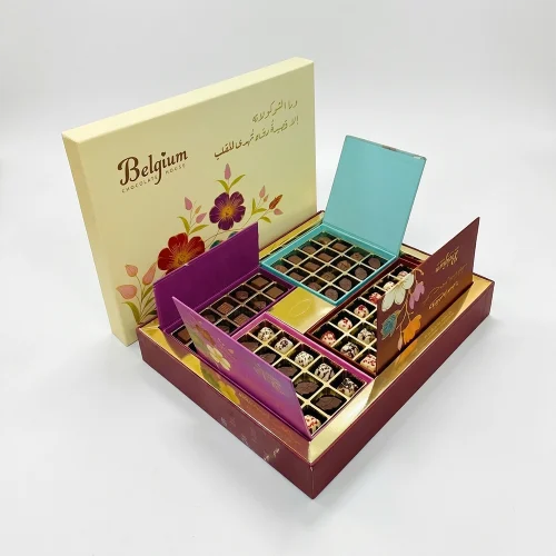 Luxury gift box of assorted Belgian chocolates in elegant packaging, featuring multiple compartments with different chocolate varieties and floral-themed design.