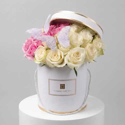 Elegant pink and white rose flower box arrangement with decorative butterfly accents in a luxury white floral box, styled for premium gifting in Dubai and Abu Dhabi.