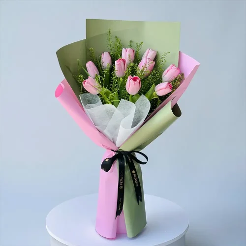 Pink tulip flower bouquet with lepidium leaves in pink and olive green wrapping