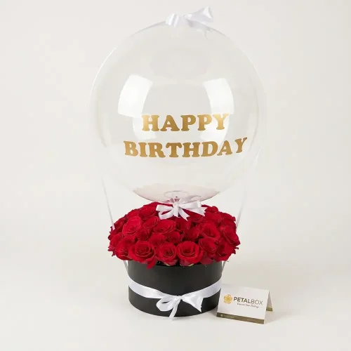 happy birthday balloon with red rose box arrangement, luxury floral gift with clear bubble balloon and black box, flower delivery in Abu Dhabi and Dubai UAE