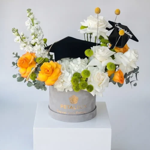 White hydrangea graduation hatbox with orange roses and green chrysanthemum, grey velvet Petal Box UAE
