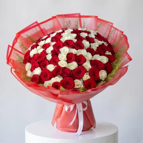 Luxury red and white rose bouquet with elegant orange wrapping and fresh greenery, designed for romantic gifting and special occasions by Petal Box.