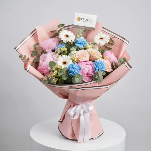 Pastel peony flower bouquet with roses, carnations, gerberas, and blush pink wrapping by Petal Box UAE