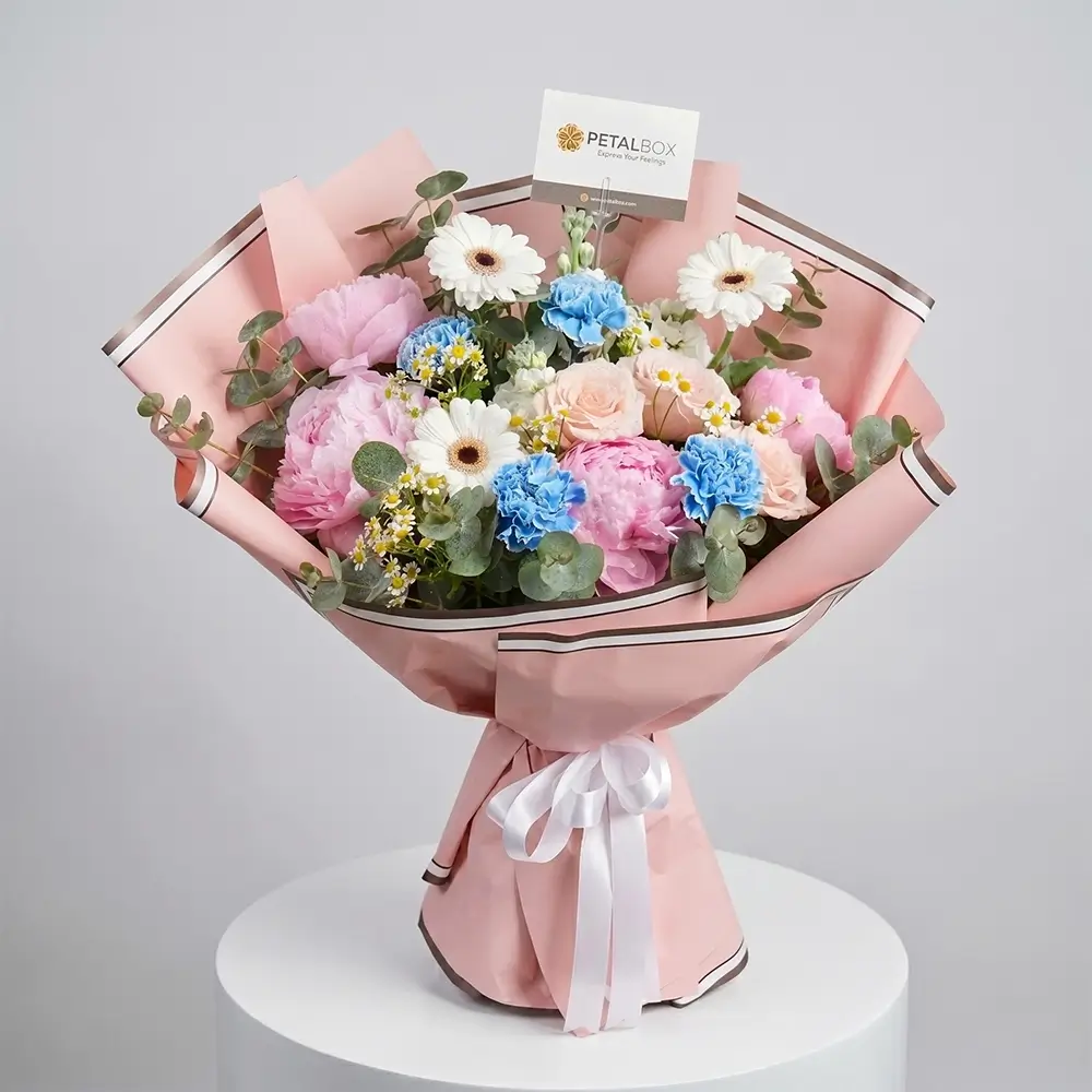 Pastel peony flower bouquet with roses, carnations, gerberas, and blush pink wrapping by Petal Box UAE